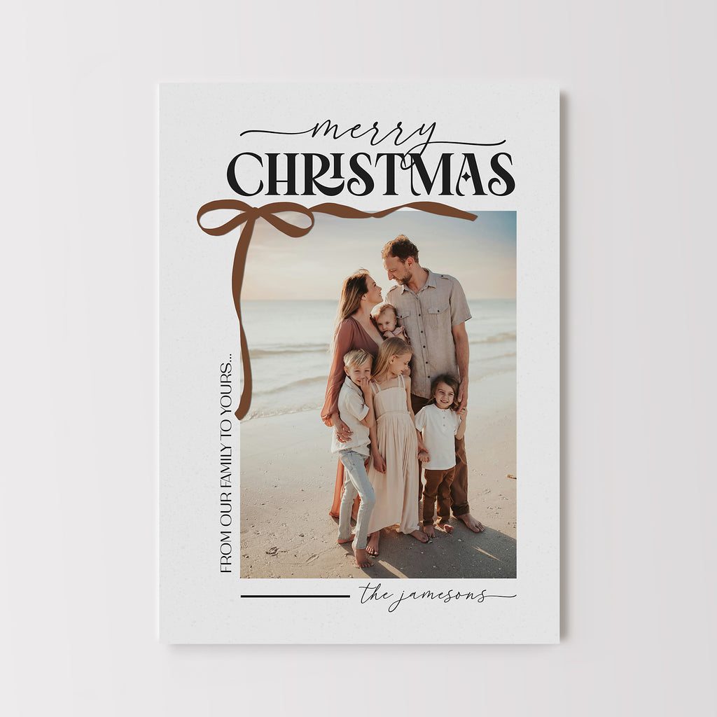 holiday or christmas photo card with a neutral light gray background, black text and bronze bow corner detail. Features a single photo on the front.