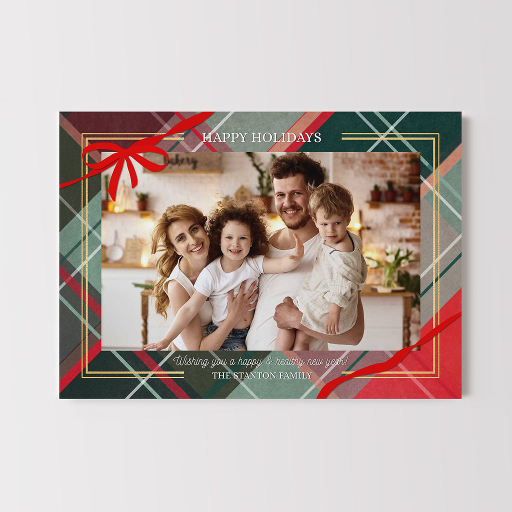 Holiday card with a family photo and festive border on a red and green plaid background