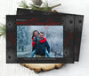 new year holiday photo card in landscape format with a single photo, black background, red text and white firework graphics