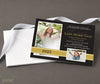 high school photo graduation announcement with a black background, gold text and a gold ribbon detail with two photos, printed on cardstock with a stack of white envelopes