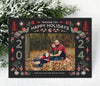 christmas photo card with a dark gray background, a single photo framed with red and green nordic themed holiday graphics