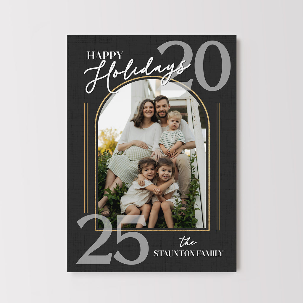 simple holiday card with black background, single arched photo, white text and gold details. 